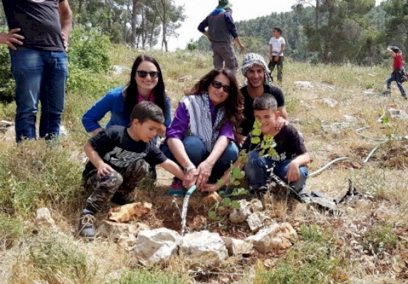 Planting native trees during an ecotourism hike in Wadi Quff reserve 